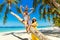Young happy family-mom, dad, daughter and son having fun on a coconut tree on a sandy tropical beach. The concept of travel and