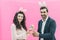 Young happy family on a pink background. At the same time on the head there is a rabbit`s ears. During this look in the