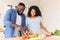 Young happy family prepares their first dish together in a new kitchen