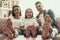 Young Happy Family puts Bare Feet on Table at Home