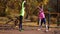 Young happy family stretching together on sports ground in autumn