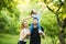 Young happy family of three having fun together outdoor. Pretty little daughter on her father back. Family fun outside.