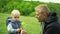 Young happy father gives a sniff of yellow flowers to his little son