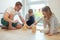 Young happy father playing with his two cute children with wooden blocks