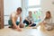 Young happy father playing with his two cute children with wooden blocks