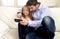 Young happy father showing sweet little girl using internet on mobile phone having fun together