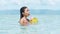 Young happy filipina tourist baths in clear ocean enjoy drinking coconut drinks