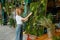 Young happy florist decorator creating plant moss panel