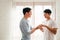 Young happy gay couple in love, proposing and marriage surprise wear a wedding ring in the living room at home. Gay men proposal