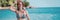 Young happy girl in bikini and with snorkeling mask laughs joyfully and walks along the beach, banner format