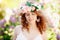 Young happy girl in the bushes of blooming lilac. Fashion portrait smiling curly woman against lilac in blossom. Positive model in