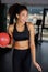 Young happy girl gives a cute smile to you while working out at gym