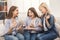 Young happy girl showing her proposal ring to surprised girlfriends