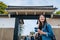 Young happy girl standing the entrance of the osaka castle. elegant attractive traveler flick hair and enjoying looking around the