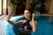 Young happy girl taking a selfie in indoor pool at wellness center