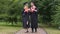 Young happy graduates holding diplomas and walking in park, talking and relaxing