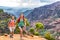 Young happy hikers people walking on Hawaii Waimea Canyon Trail, Kauai island, USA. Asian woman and man couple trekkng in scenic