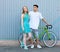 Young happy hipster couple in love meet each other and dating whis vintage bicycle. Pretty blonde caucasian woman with her