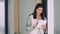 Young happy Indian business woman using tablet standing in office.