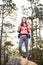 Young happy jogger standing on rock looking at camera