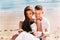 Young happy and joyful Caucasian adult romantic couple in white summer wear - Boyfriend and girlfriend reading a book together