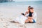 Young happy and joyful Caucasian adult romantic couple in white summer wear - Boyfriend and girlfriend reading a book together