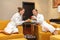 Young happy just married Caucasian couple in white bathrobes having fruits after spa on honeymoon. Man offers an apple to the