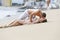 Young happy kissing couple on ocean beach, laying on sand.