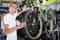 Young happy man buyer checking tire on cycle wheel