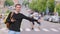 Young happy man catch a taxi in european streets. Portrait of a caucasian tourist with backpack smiling and catching a