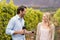 Young happy man offering wine to a young woman