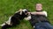 Young happy man plays with dog Lapland Reindeer dog in summer on grass