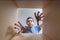 Young happy man is stretching hands. View from inside cardboard box