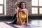 Young happy mother doing stretching exercise on mat while her smiling daughter hugging her in sports club