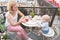 Young happy mother having coffee with baby on balcony outdoor