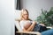 Young happy mother sits at home with her baby