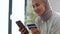 Young happy muslim woman in hijab paying online with smartphone and credit card, entering personal data in app