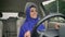 Young happy muslim woman in hijab sitting behind self-driving steering wheel of autonomous autopilot driverless car