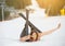 Young happy naked female skier is lying on snowy slope near ski lift at ski resort