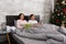 Young happy pair reading books while lying in the bed in the bed