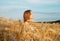 Young happy peaceful woman inside golden wheat field in summer. Meditation and peace concept