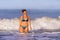 Young happy and playful red hair woman in bikini swimming on the sea playing with big waves enjoying Summer holidays paradise