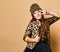 Young happy plus size girl model in stylish leopard colored clothing and black skirt standing, smiling and showing peace sign