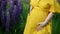 A young happy pregnant woman gently touches and hugs her belly. Pregnant girl in a yellow long dress in a field.