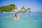 Young happy and pretty Asian Korean tourist woman enjoying swimming at tropical paradise beach island with tourquoise cyan sea wat