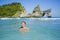 Young happy and pretty Asian Korean tourist woman enjoying swimming at tropical paradise beach island with tourquoise cyan sea wat