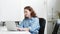 Young happy professional business woman sitting at desk working on laptop.