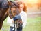 Young happy rider woman with her bay horse