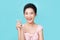 Young happy romantic affectionate Asian woman shapes mini heart gesture with fingers demonstrating a sign of love