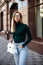 Young happy stylish trendy business woman posing near old historic buildings, stay on the street and waiting for friends.